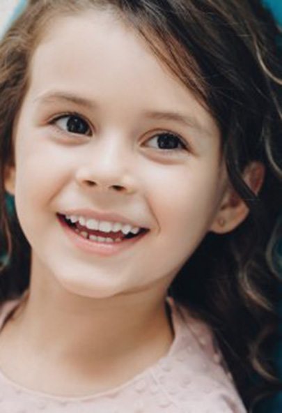 Girl smiling at her dentist from the patient’s chair