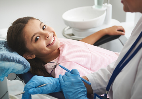 Smiling girl leaning back in the dental chair