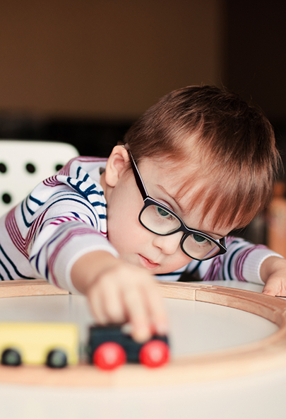Child playing with a toy train set