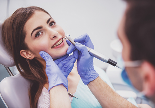 Teenage girl in the dental chair getting a professional teeth cleaning
