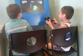 Two kids playing a video game in the dental office