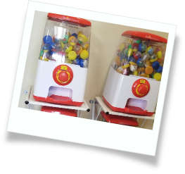 Two gumball machines with small toys inside of them