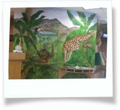 Wall art of trees in a jungle with a giraffe and a monkey