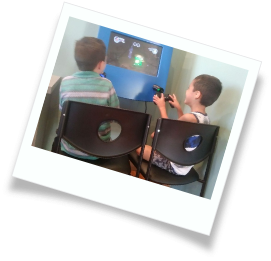 Two kids playing a video game in their pediatric dental office