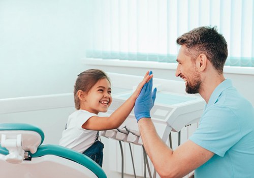 Child giving the dental assistant a hi-five