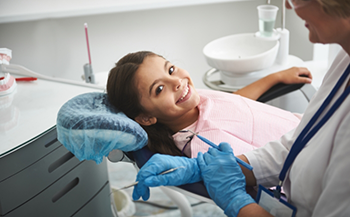 Smiling girl leaning back in the dental chair before receiving pediatric dental services in Bakersfield