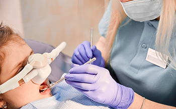 Child receiving a dental treatment while wearing a nitrous oxide mask over their nose