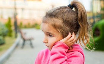 Young girl holding the side of her face in pain