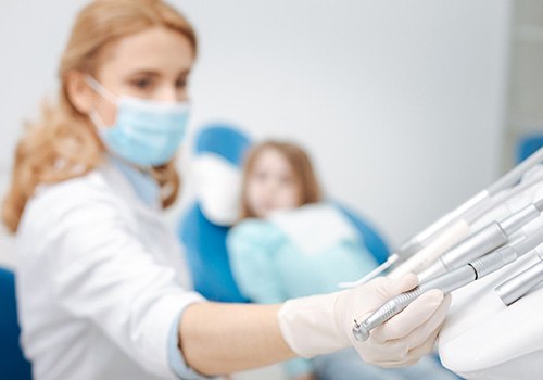 Dentist reaching for instrument