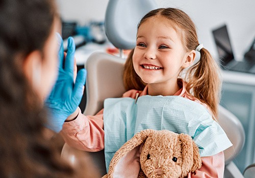 Little girl giving dentist a high-five during a visit