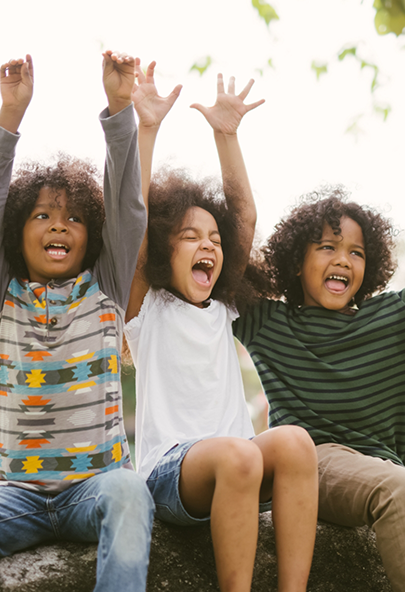 Three kids cheering outdoors