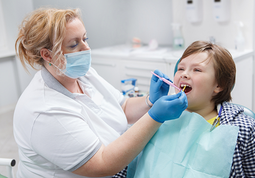Child in the dental chair having fluoride applied to their teeth