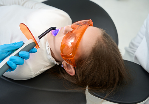 Child dental patient having an ultraviolet light applied to their teeth