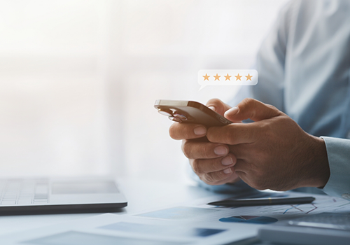 Person typing a five star review on their phone