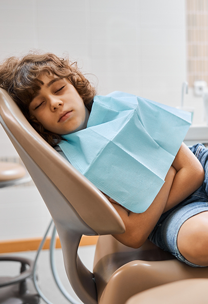 Boy sleeping on his side in the dental chair after sedation dentistry in Bakersfield