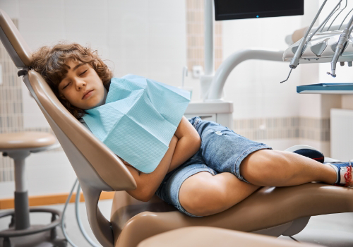 Boy sleeping on his side in the dental chair