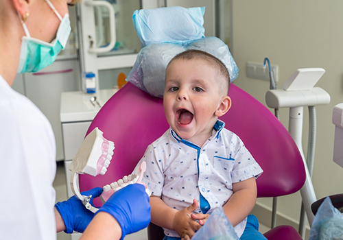 Child in the dental chair opening their mouth wide