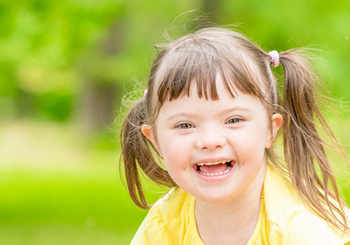 Young girl with pigtails smiling outdoors
