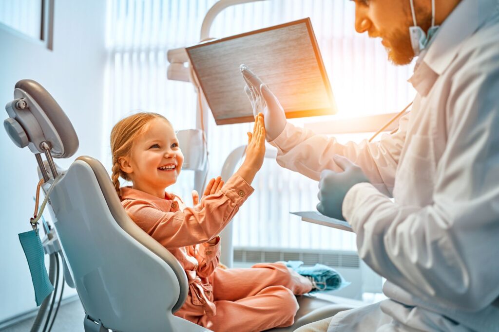 A little girl high fiving her dentist